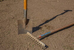 closeup-shot-of-a-rake-and-a-shovel-on-garden-soil-2023-11-27-05-01-17-utc